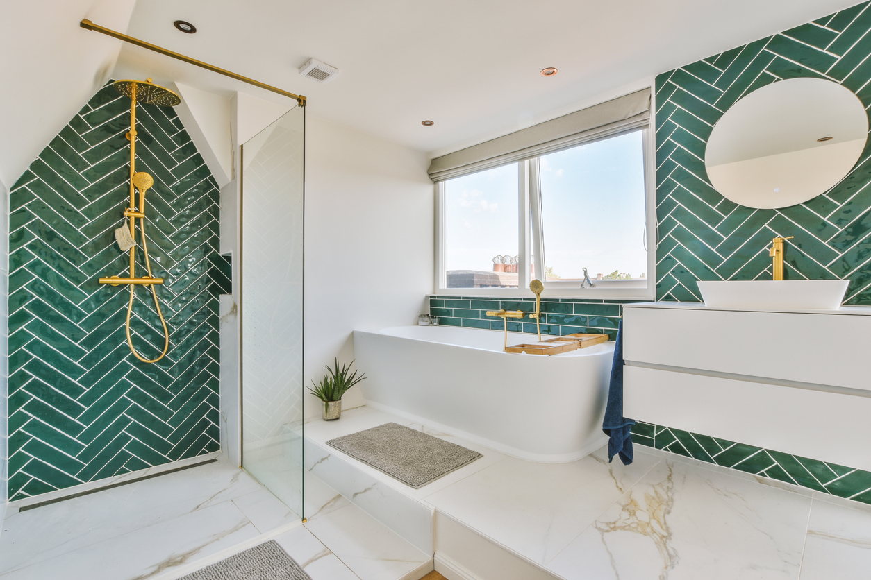 L'intérieur d'une salle de bains décorée de marbre et d'équipements dorés dans une maison moderne