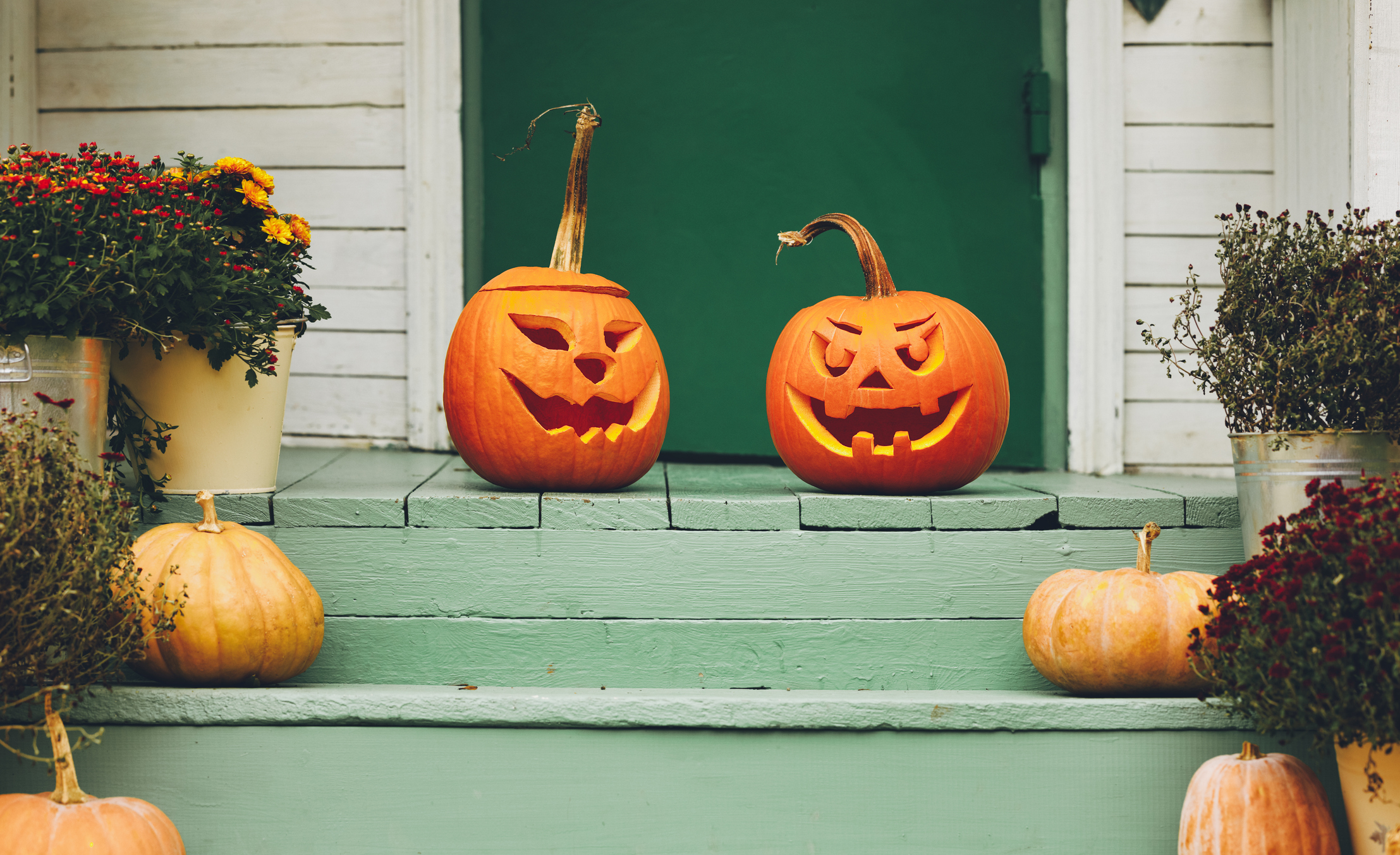 Maison avec décoration de citrouille orange d'Halloween, lanternes Jack O avec des visages effrayants sur le porche