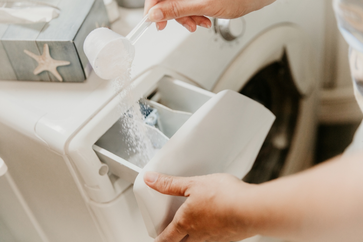 Adding white detergent powder to washer