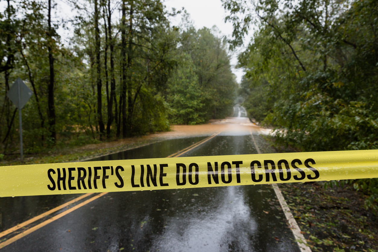 Police tape cordoning off a flooded road