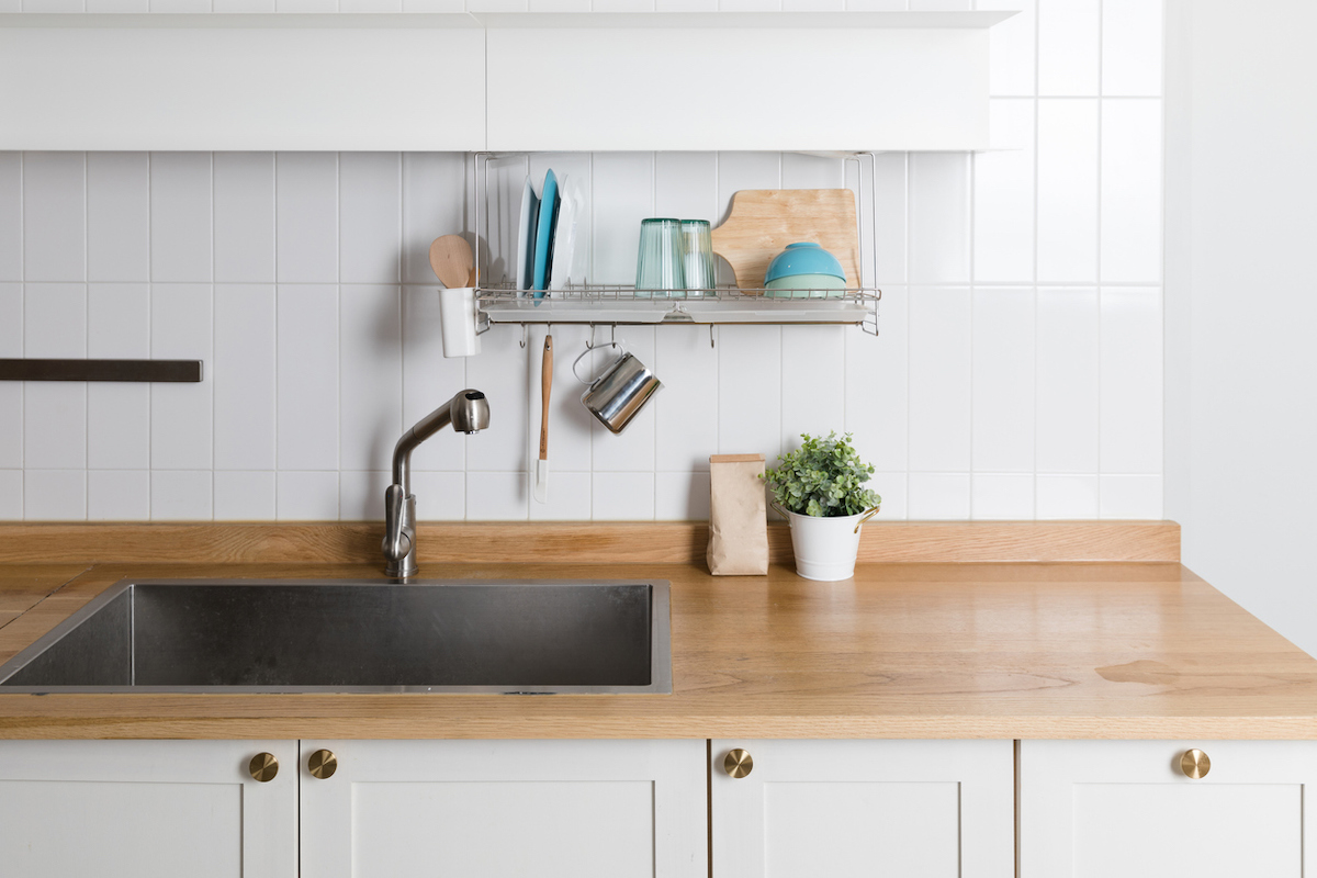 a butcher block countertop in a modern kitchen with white cabinets