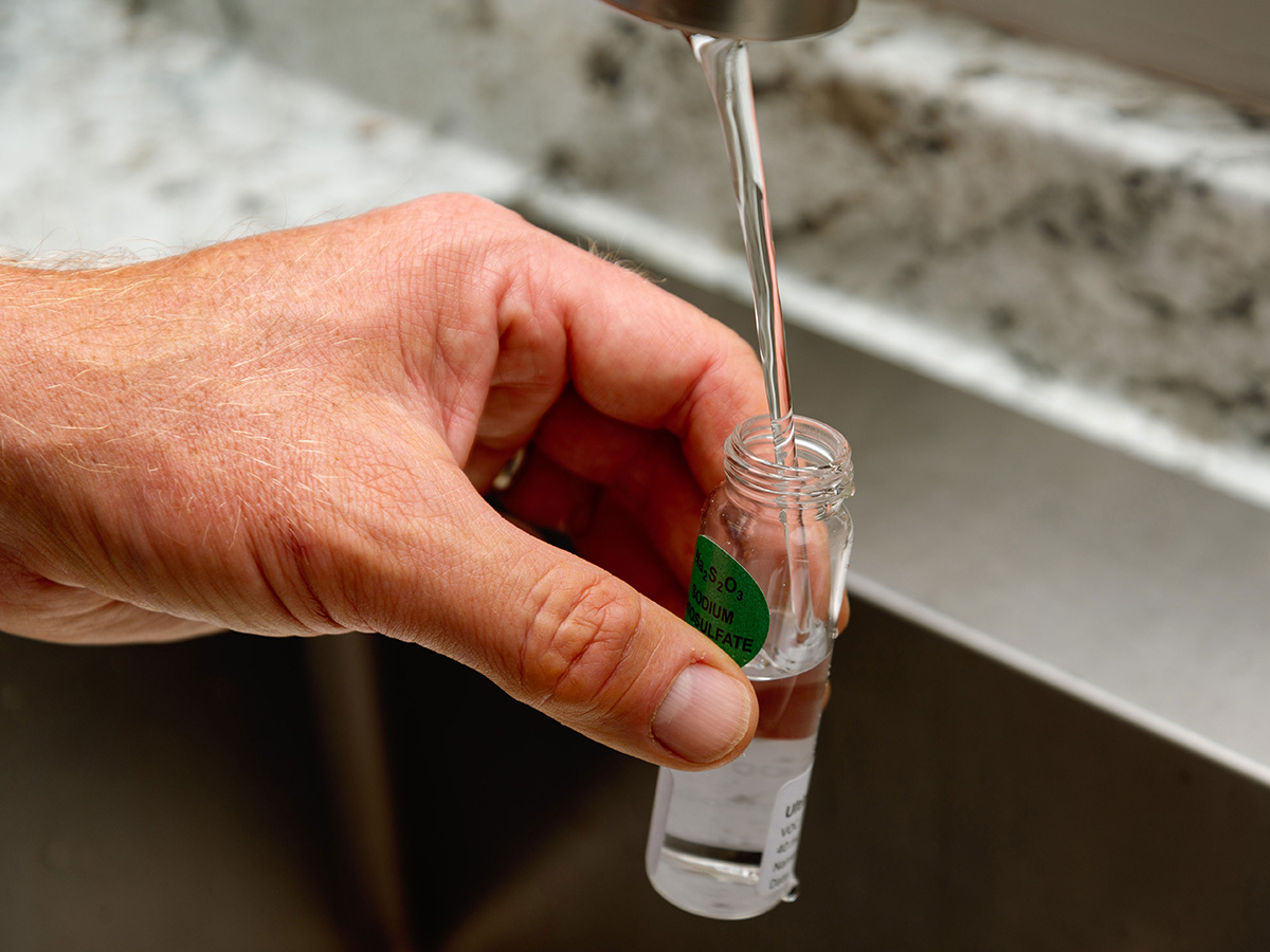 Man filling vial from Safe Home Ultimate Drinking Water Test Kit