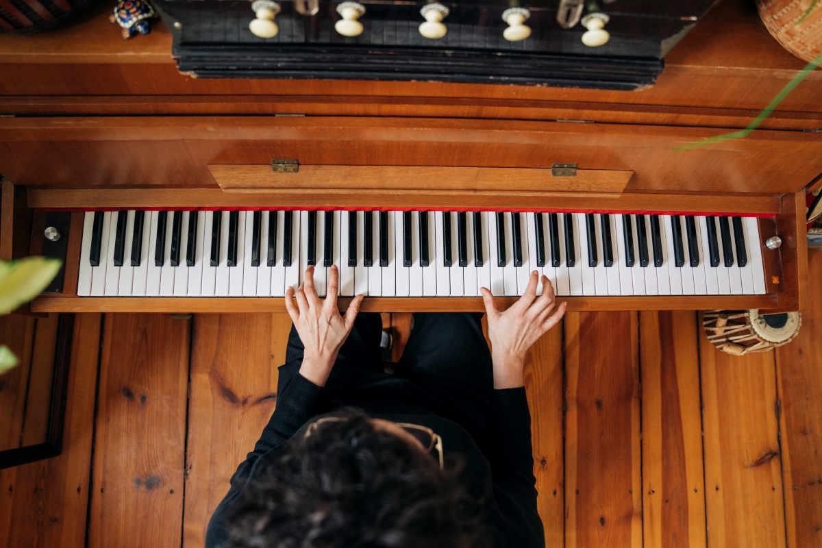 Woman playing the piano with two hands.