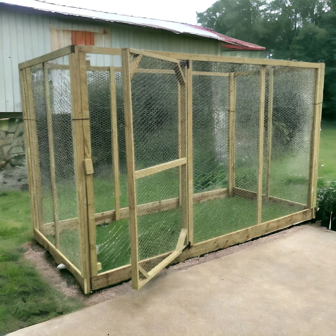 A large, plain outdoor box structure suitable for chickens as a coop or cats as a catio stands in a rural backyard.