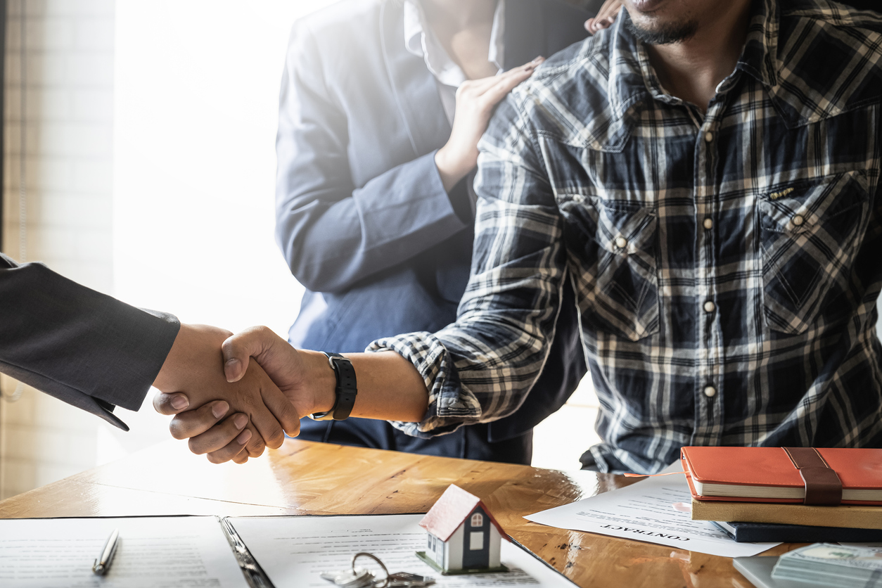 Agent and couple meeting and handshaking after good deal for buy house