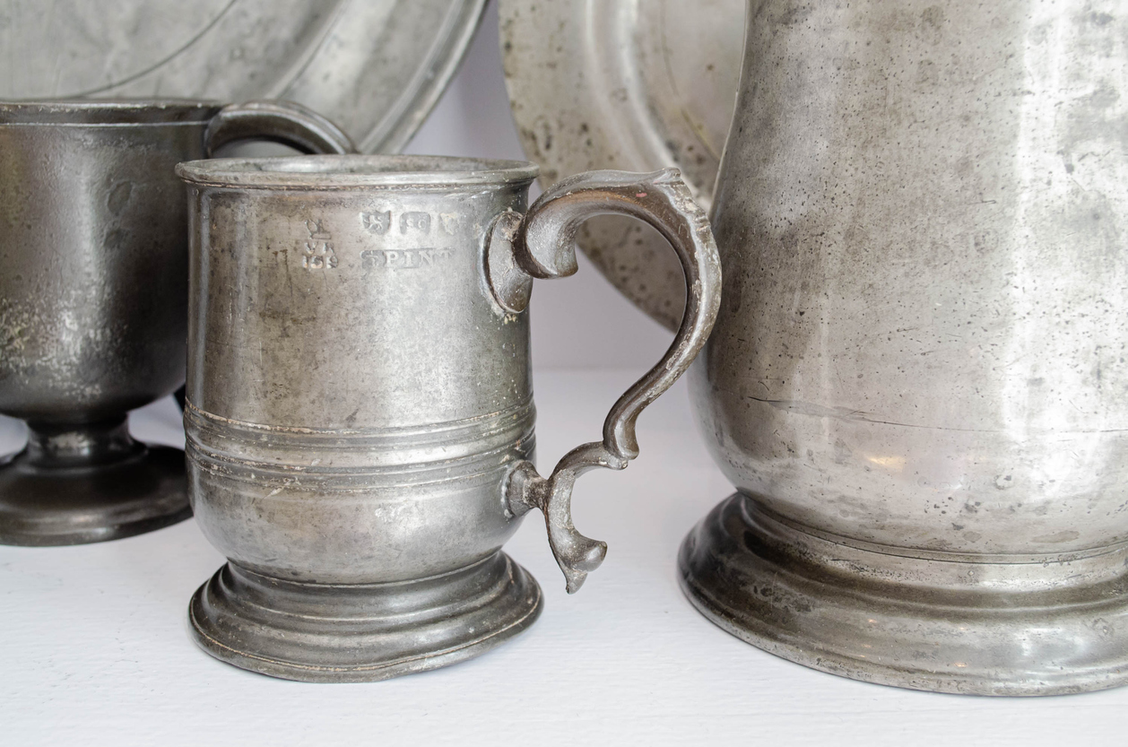 Several pewter dishes sitting together.