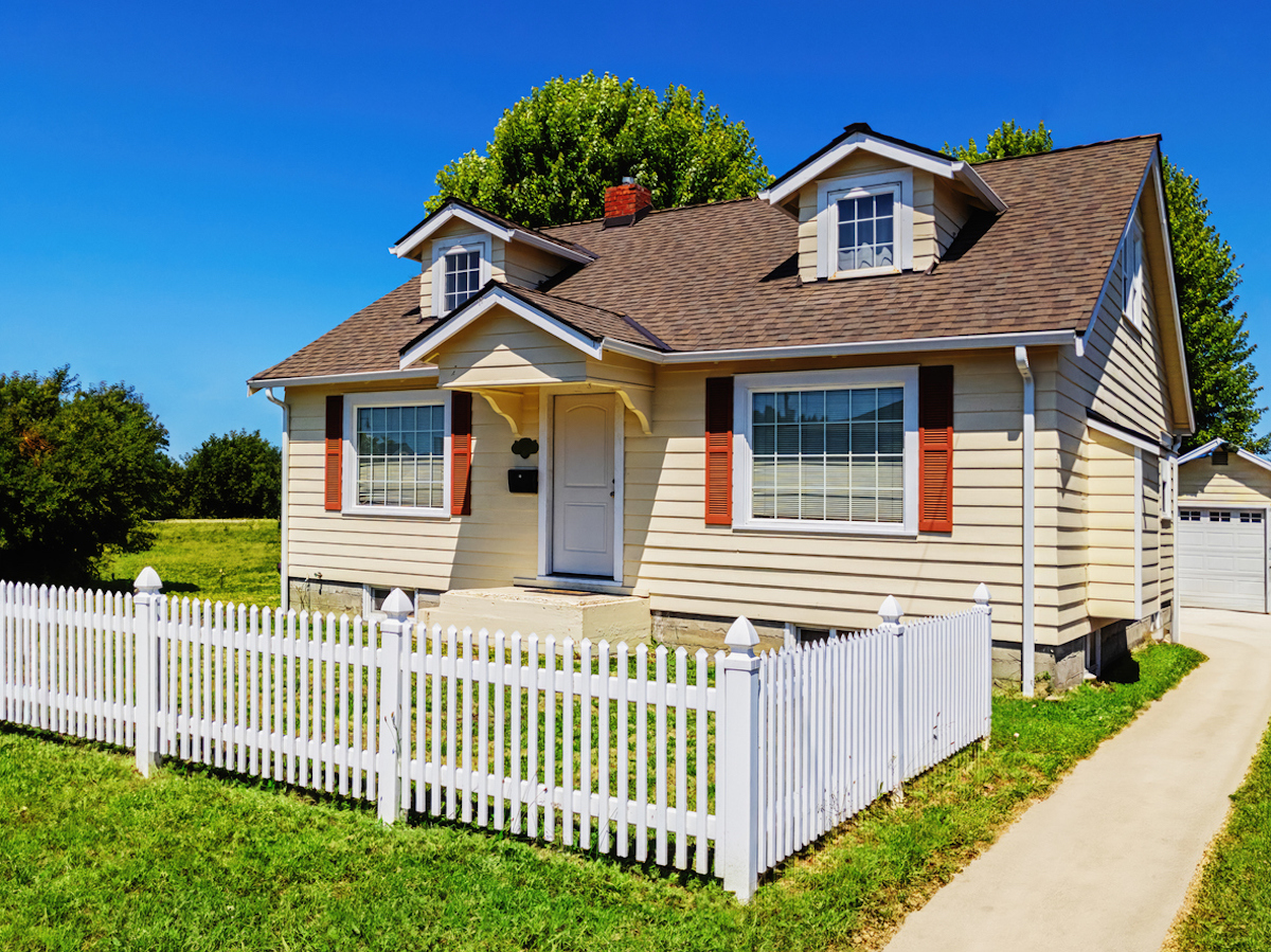 small house with partial picket fence in the front yard