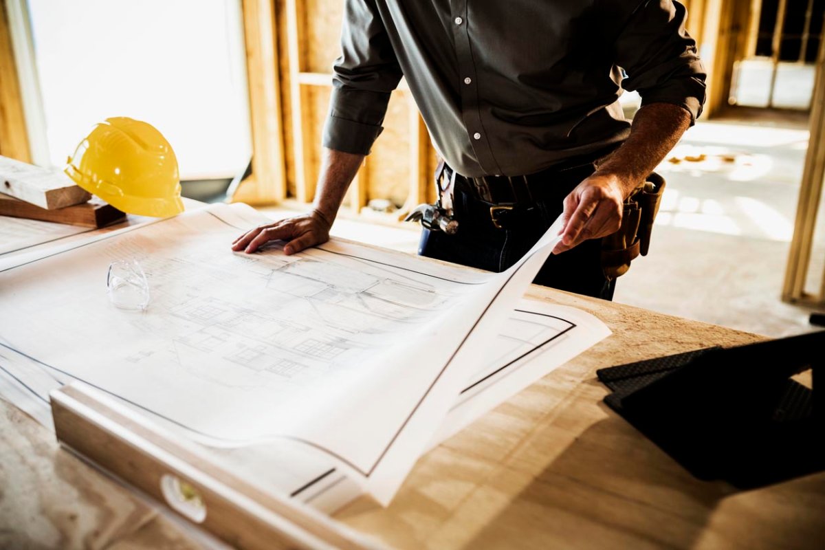 A close up of a worker looking a home building plans. 