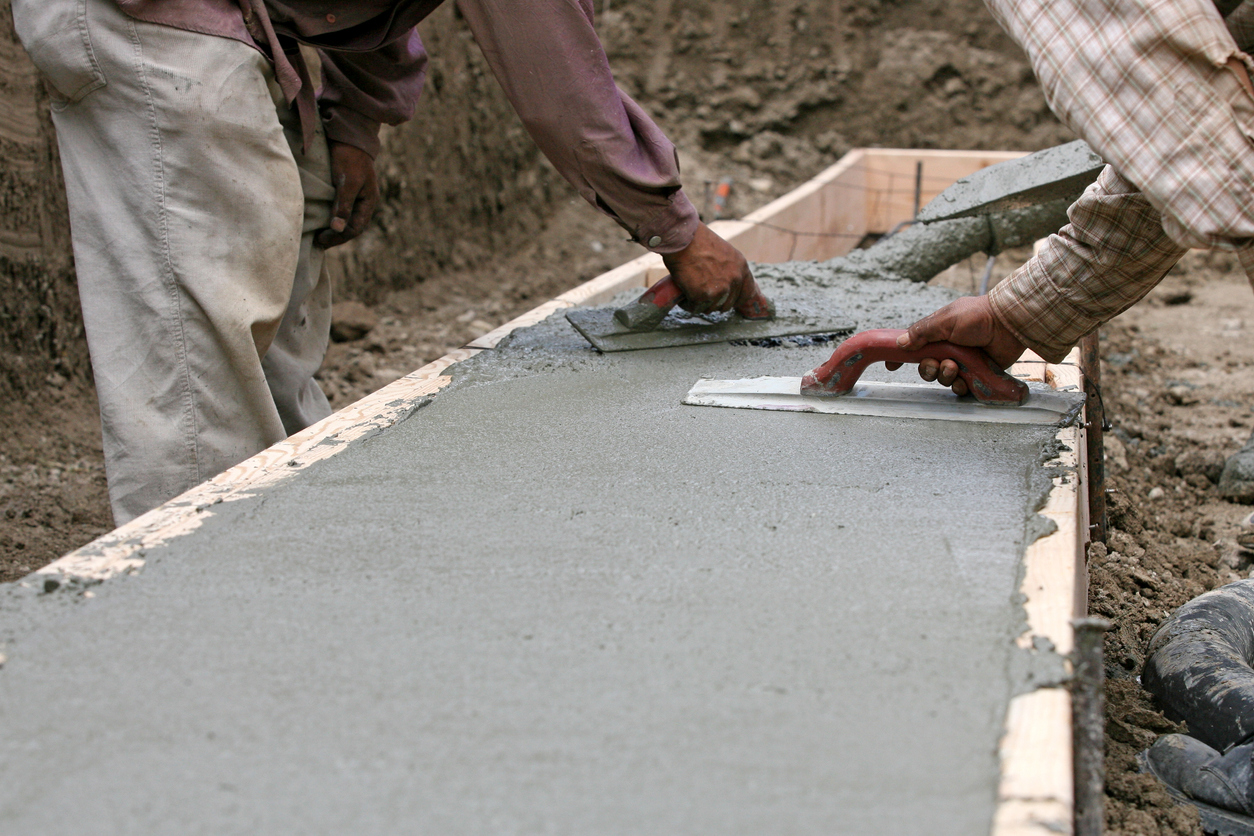 Constrution workers spreading wet concrete.