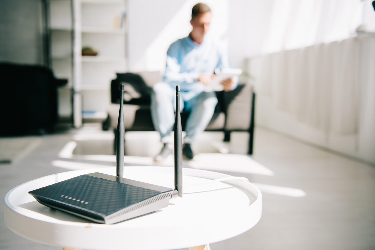 modem vs router router on table in home office man working in background