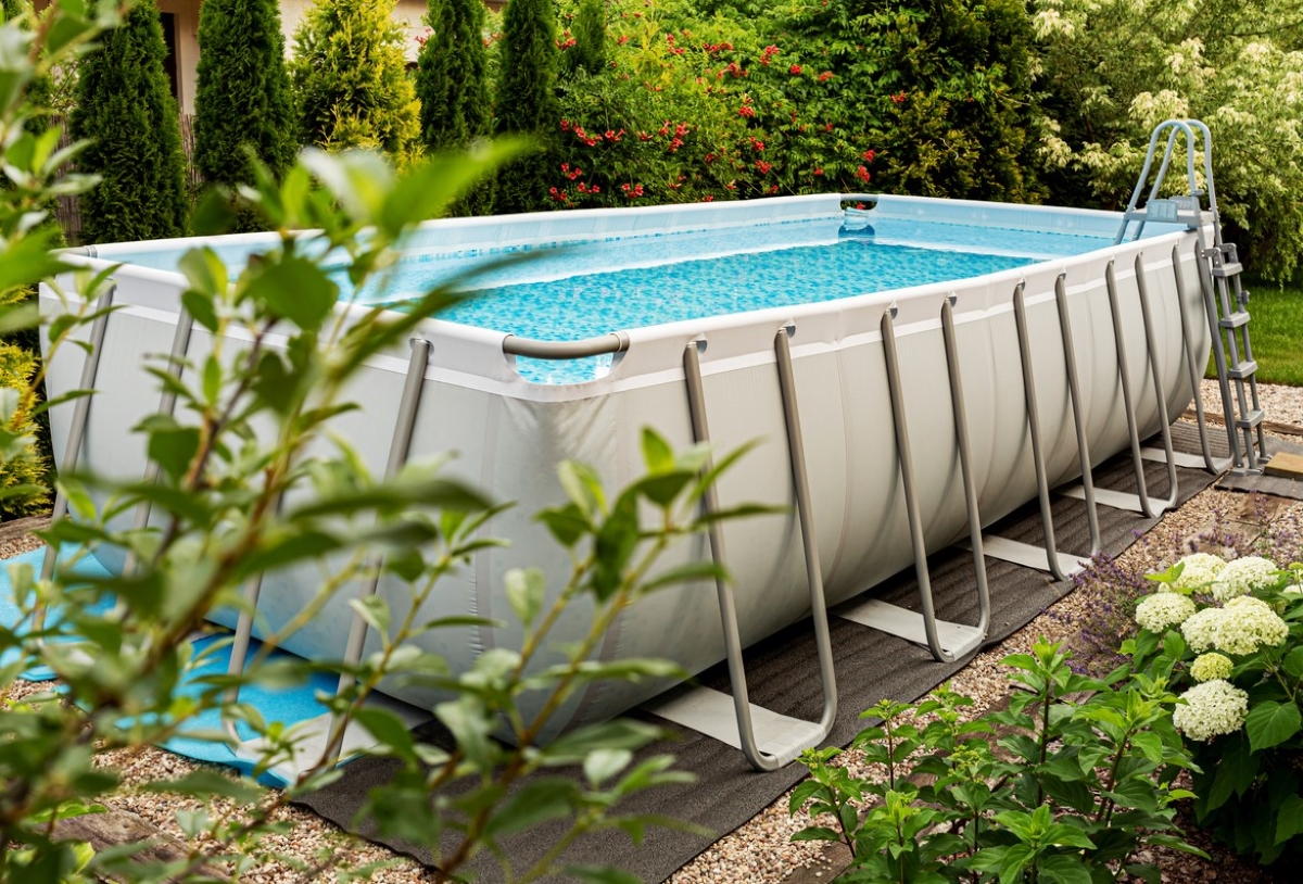 Rectangular above ground pool in yard.