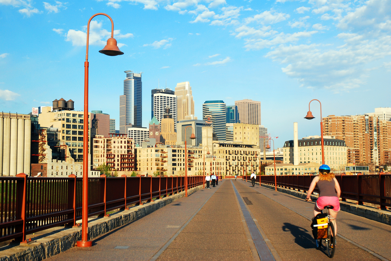 Un cycliste pédale sur le pont Stone Arch, en direction du centre-ville de Minneapolis, Minnesota