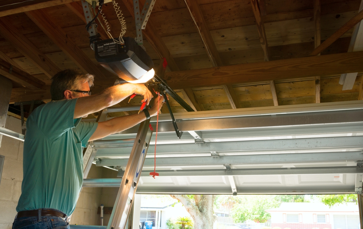 mise en scène de garage - homme réparant la porte de garage