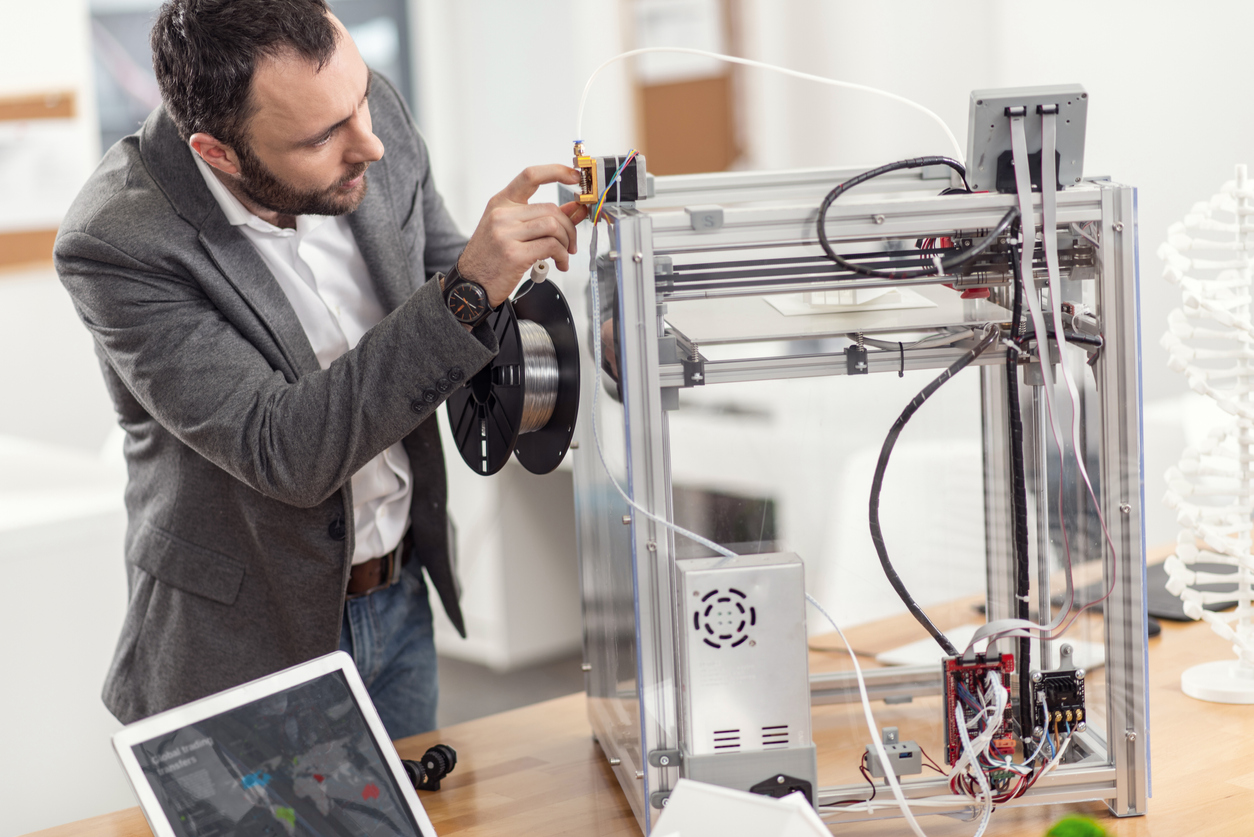 iStock-925925590 volunteer opportunities young man refilling filament into 3d printers