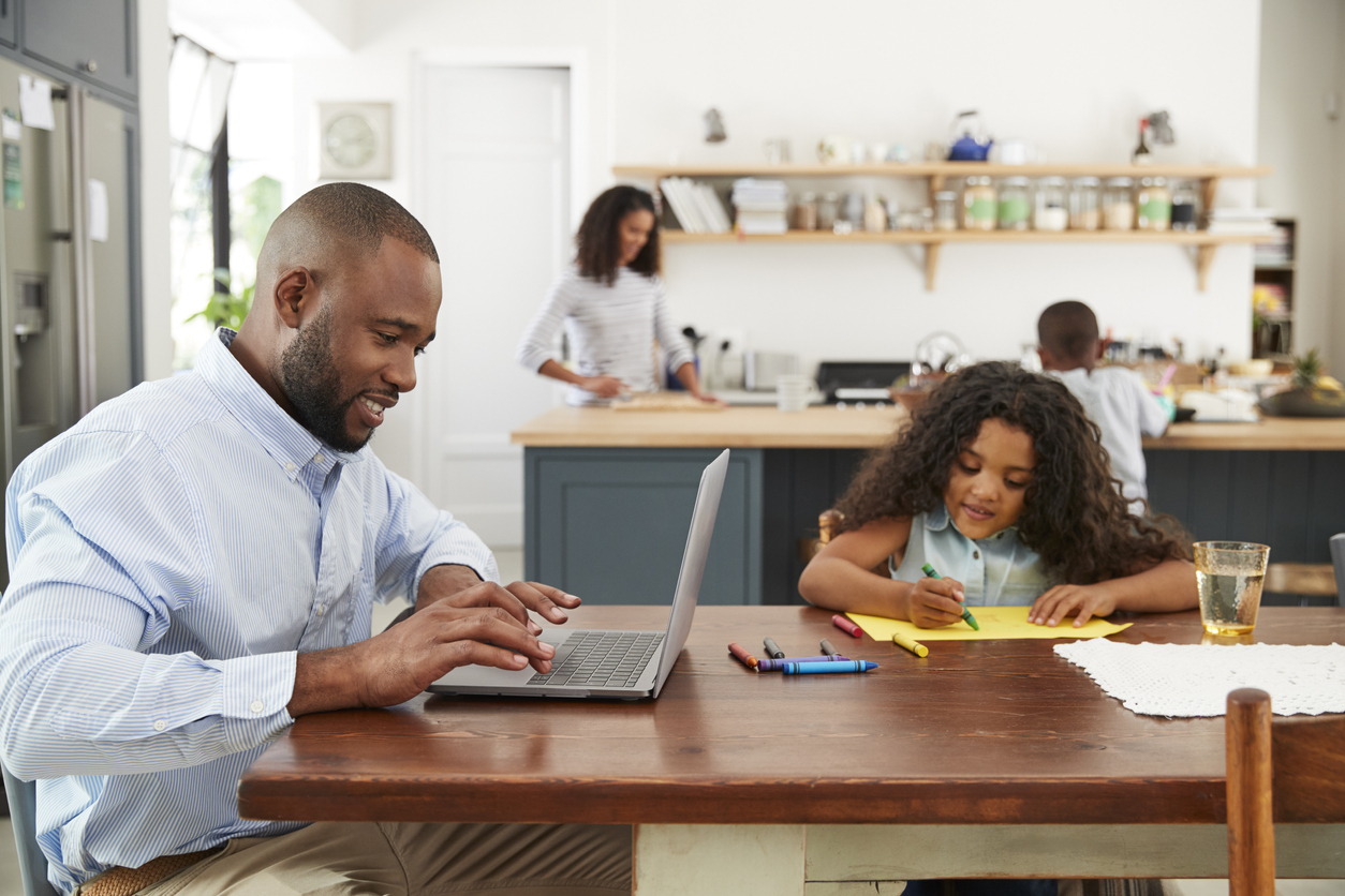 The 11 Biggest Mistakes You Can Make With Your Smart Home man in kitchen with family doing research on laptop