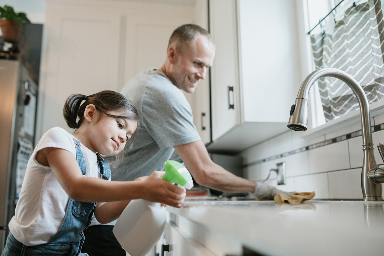 Father and Daughter Disinfecting Kitchen Surfaces Together