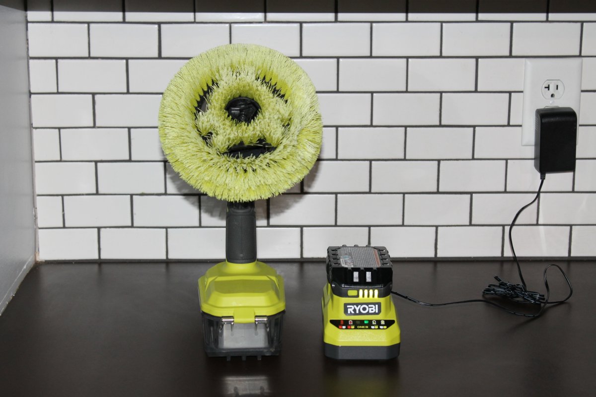 Ryobi One+ 18V Power Scrubber sitting on kitchen counter next to charger