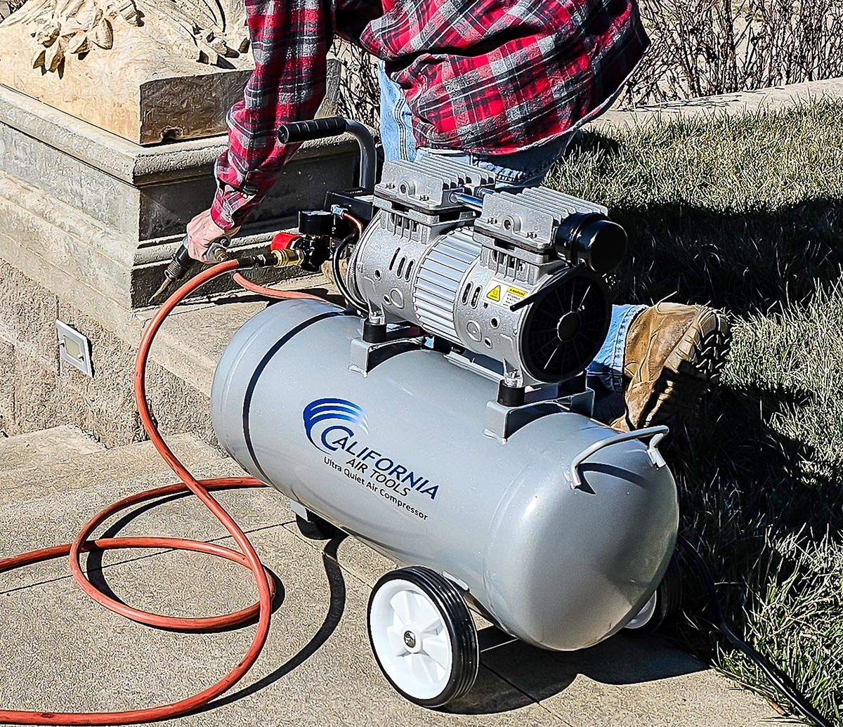 Une personne utilisant le compresseur d'air ultra silencieux California Air Tools 8010 avec un outil électrique pendant les tests.