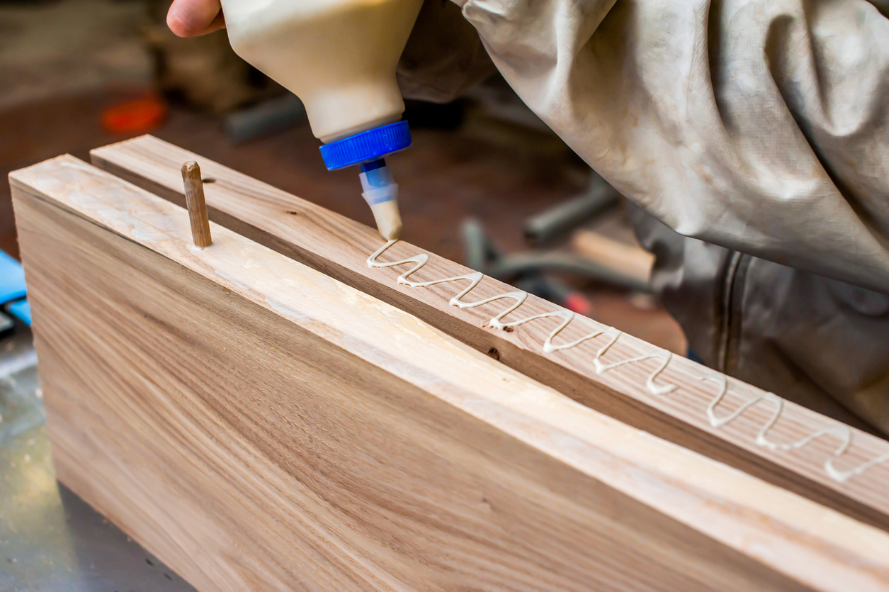 Gluing boards in a carpentry workshop. Connecting with dowels and glue. Manufacturing of furniture boards and countertops.