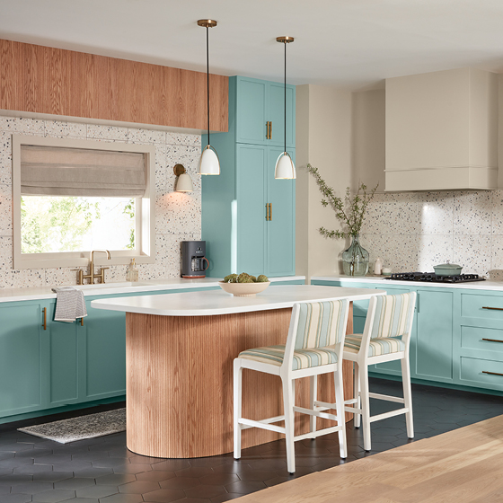 Kitchen with light wooden cabinets and white countertops features cabinets in Renew Blue.