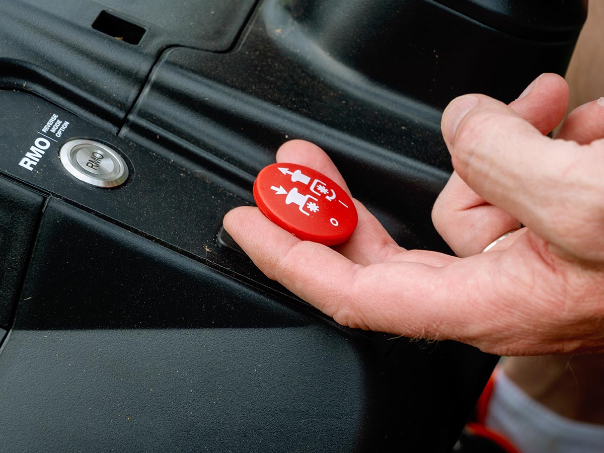 Hand lifting the red blade engage knob on a Ryobi Lawn Tractor