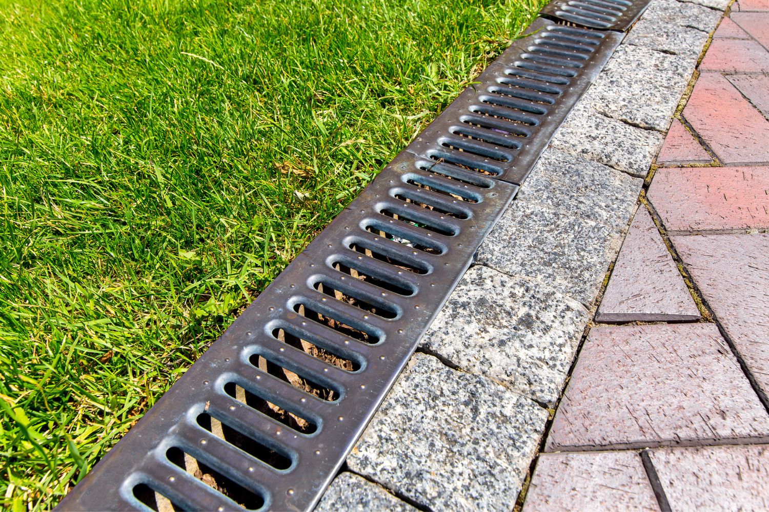 Gros plan d'un système de drainage dans une cour.