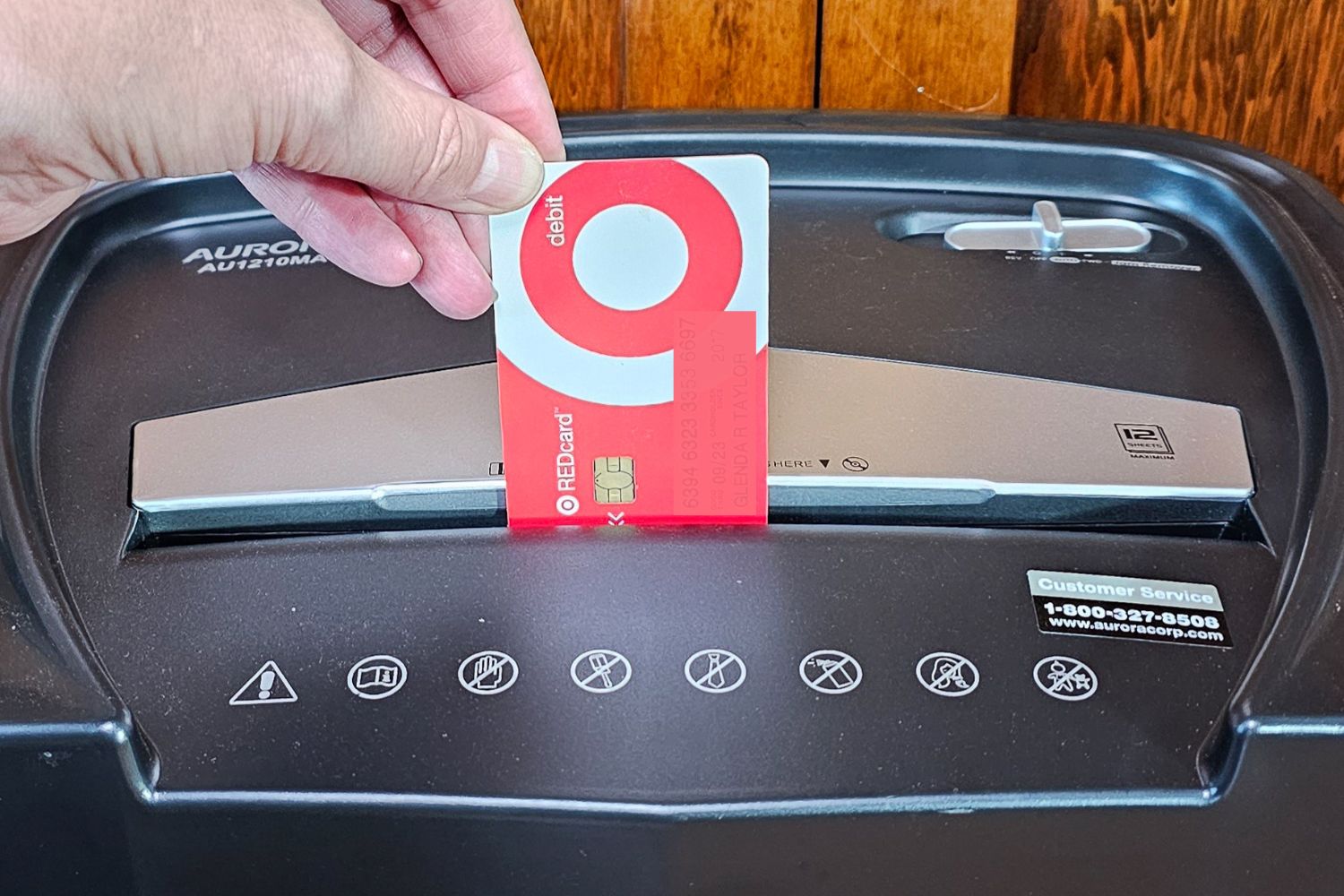 A person putting a credit card into the Aurora paper shredder