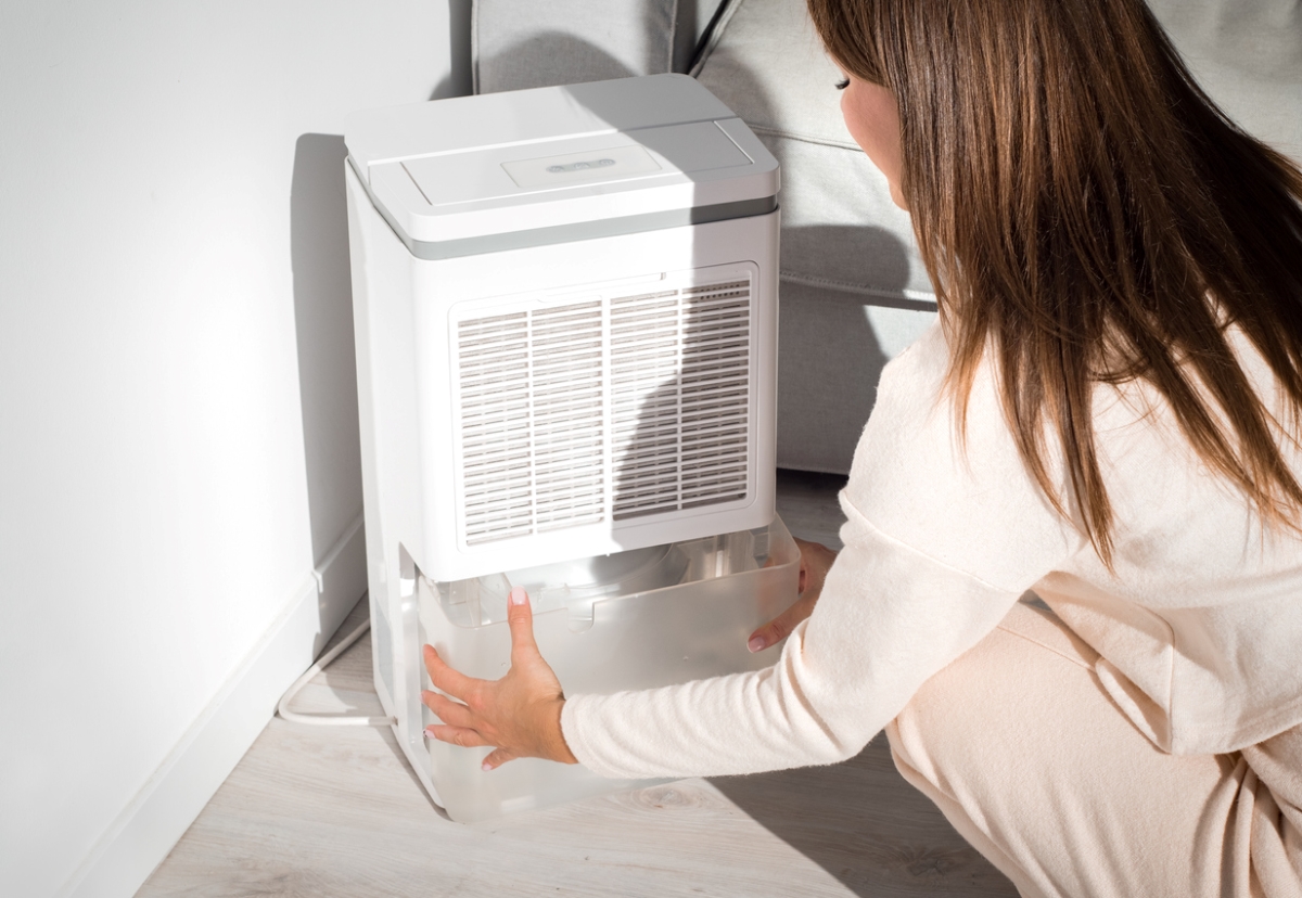 Woman pulling humidifier water container.